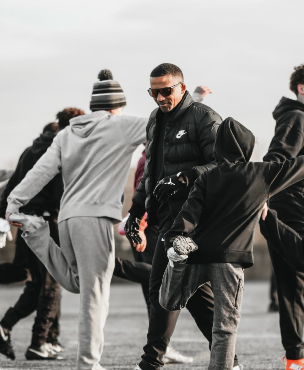 Greg Fenner Jr. running an outdoor sports training business camp with youth athletes